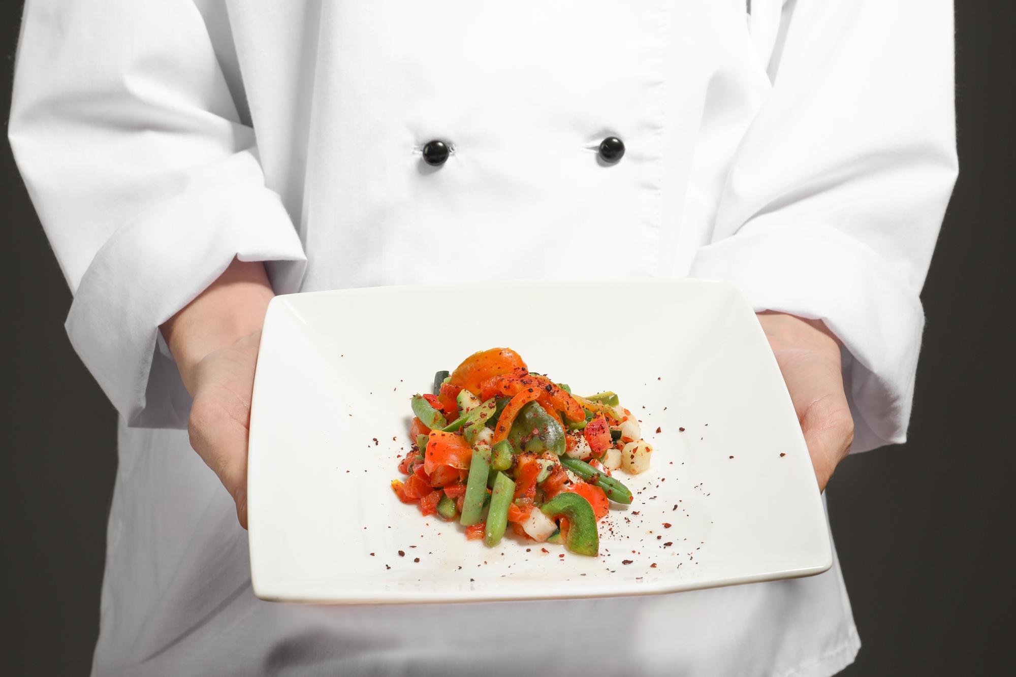 Instructor demonstrating a plated dish in an online class